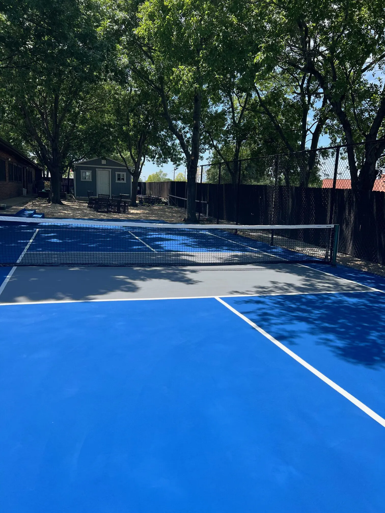 A tennis court with two blue and one grey.