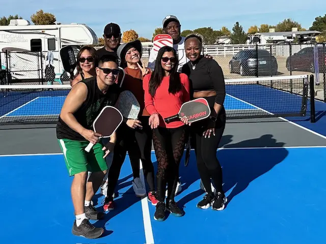 IMG_1521 A group of people standing on top of a tennis court.