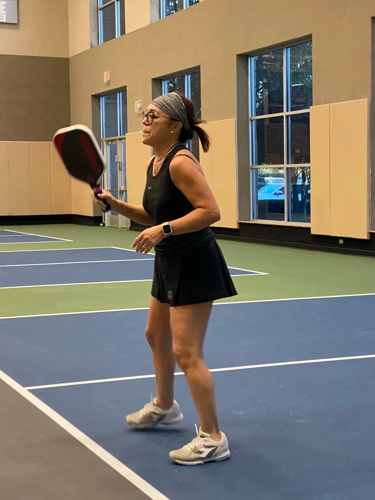 A woman holding a racquet on top of a tennis court.